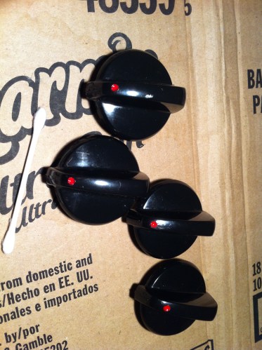Stove knobs with drilled hole filled in with red nail polish